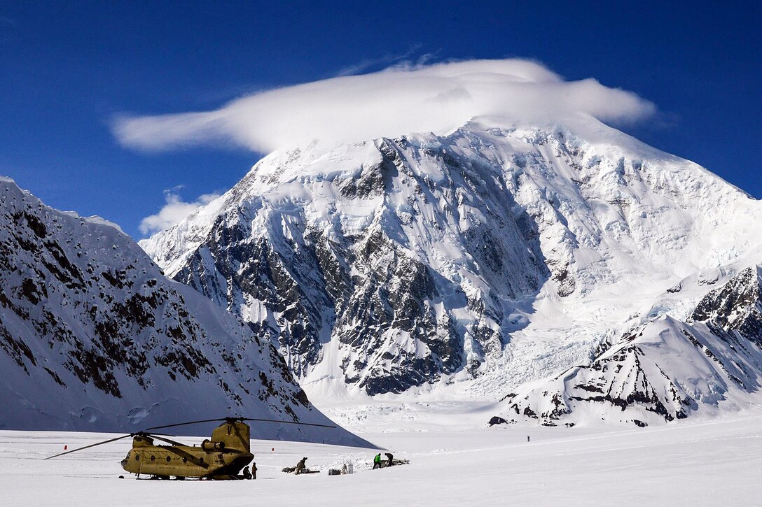 At 17,400 feet, Mount Foraker towers above soldiers as they offload equipment and supplies from a CH-47F Chinook helicopter after landing on Kahiltna Glacier in Denali National Park and Preserve, Alaska, April 24, 2016. Army photo by John Pennell