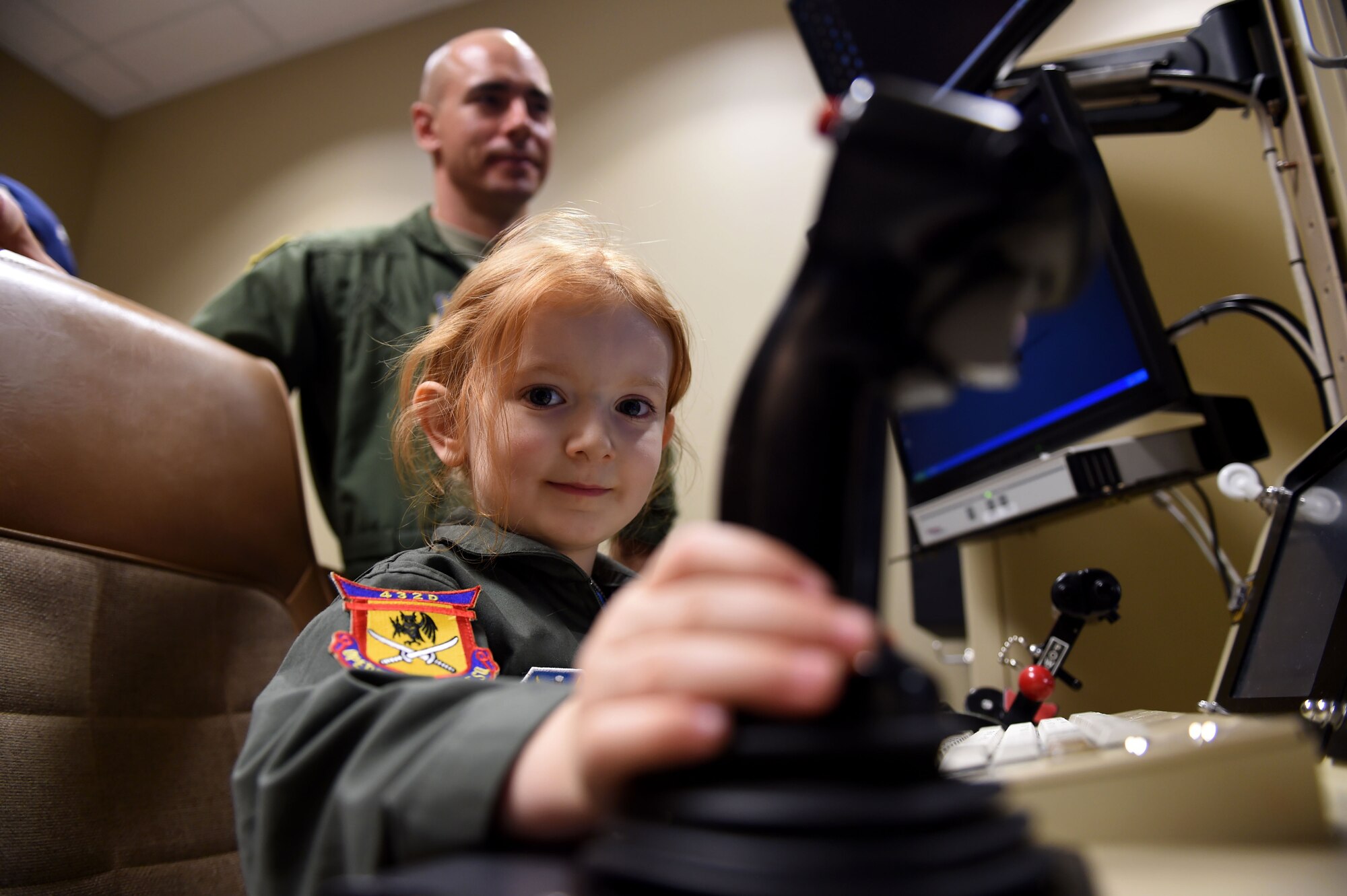 A child experiences the MQ-1 Predator and MQ-9 Reaper simulators during the “Take Your Kid to Work Day” event April 28th, Creech Air Force Base, Nevada. The event was hosted by the 432nd Wing to teach children of Team Creech about base mission sets and consisted of fun activities, squadron tours, and demonstrations from the 799th Security Force Squadron and Nellis/Creech Fire Department.(U.S. Air Force photo by Senior Airman Adarius Petty/Released)