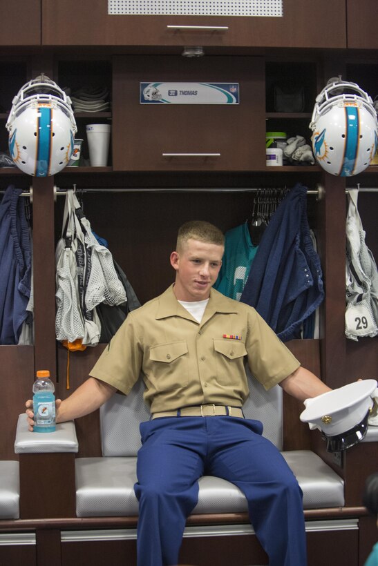 Pfc. Geoffery Smith, an ammunition technician with Combat Logistics Regiment 25, poses for a photo in the players locker room during a tour of the Miami Dolphins training facility in Fort Lauderdale, Fla., May 4, 2016. The event took place as a part of Fleet Week Port Everglades which lasts from May 2-8, and will give the community of South Florida the opportunity to interact with the Marines and Sailors from several fleet ships as well as see up-close and personal some of the capabilities and equipment the Marine Corps employs. (U.S. Marine Corps photo by Cpl. Michelle Reif/Released.)