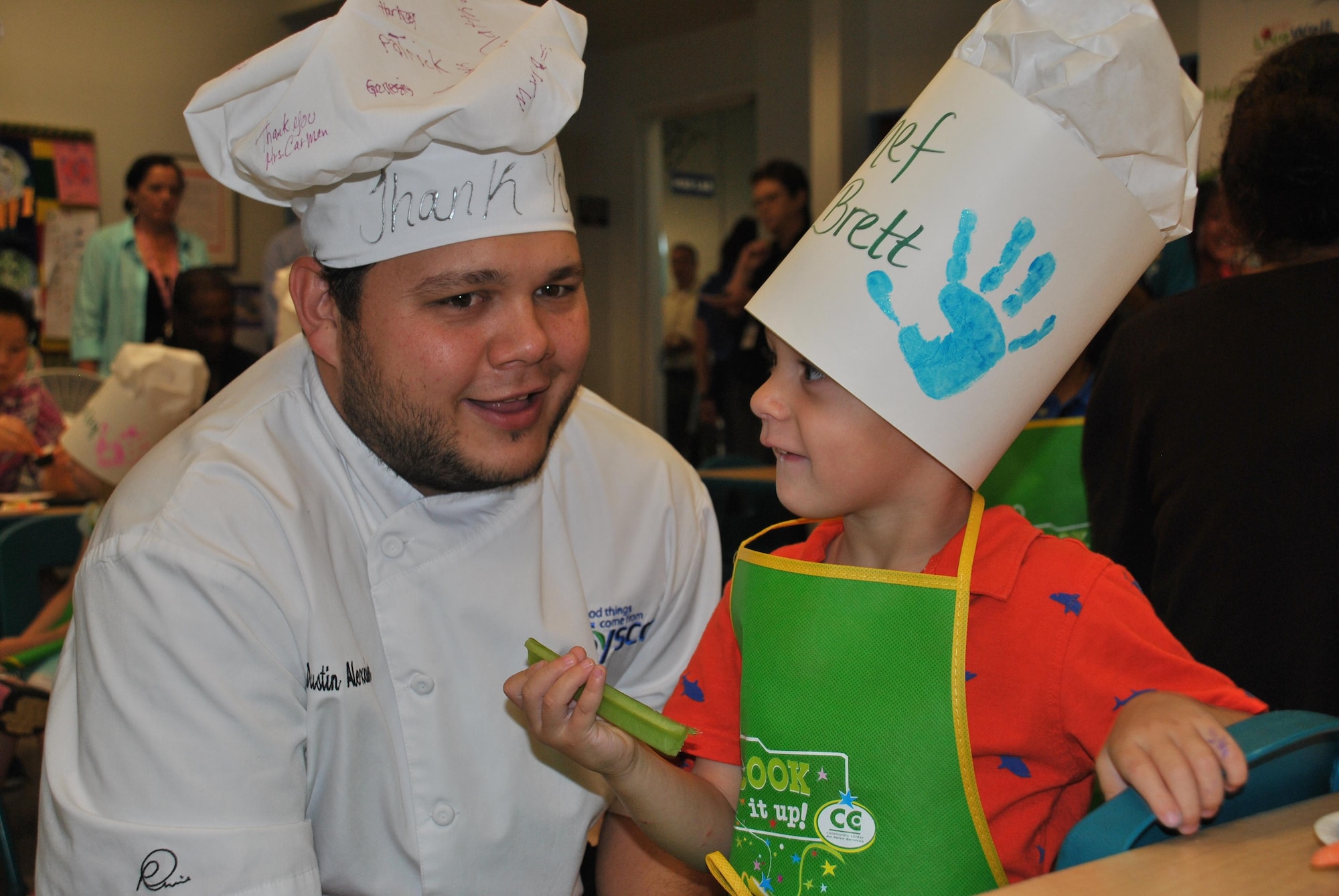 Dustin Alexander, a chef with Sysco Foods, visits with "Chef Brett" during the kickoff of Kids LiveWell at Joint Base San Antonio-Lackland on April 21. Alexander whipped up a yogurt-based dip for celery and carrot sticks during the presentation. (U.S. Air Force photo/Carole Chiles Fuller/Released)