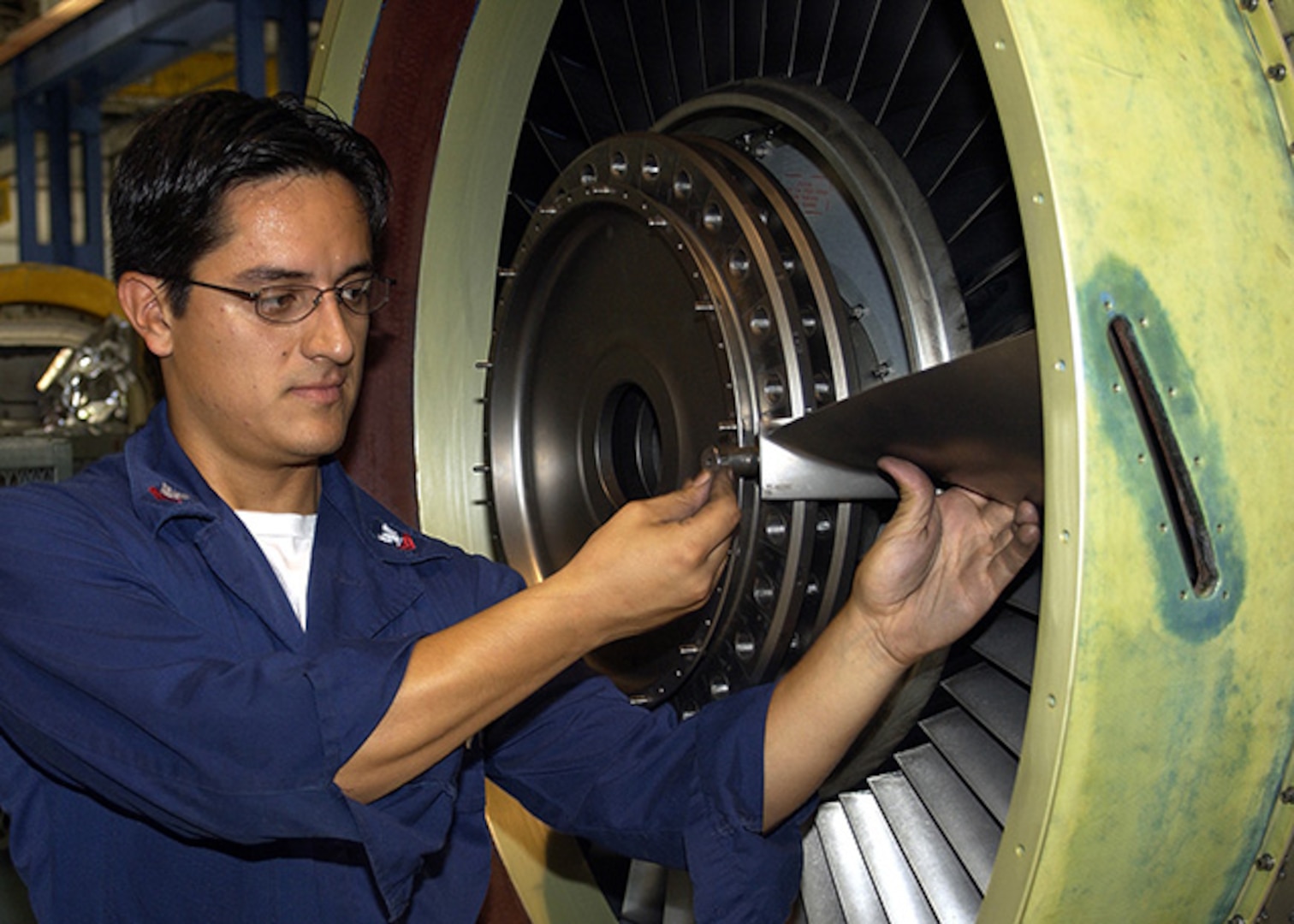 Aviation Machinist's Mate Navy Petty Officer Second Class Juan C. Loja replaces fan disk on a TF-34 S-3 Viking engine at Aviation Intermediate Maintenance Department, Jacksonville, Florida.
