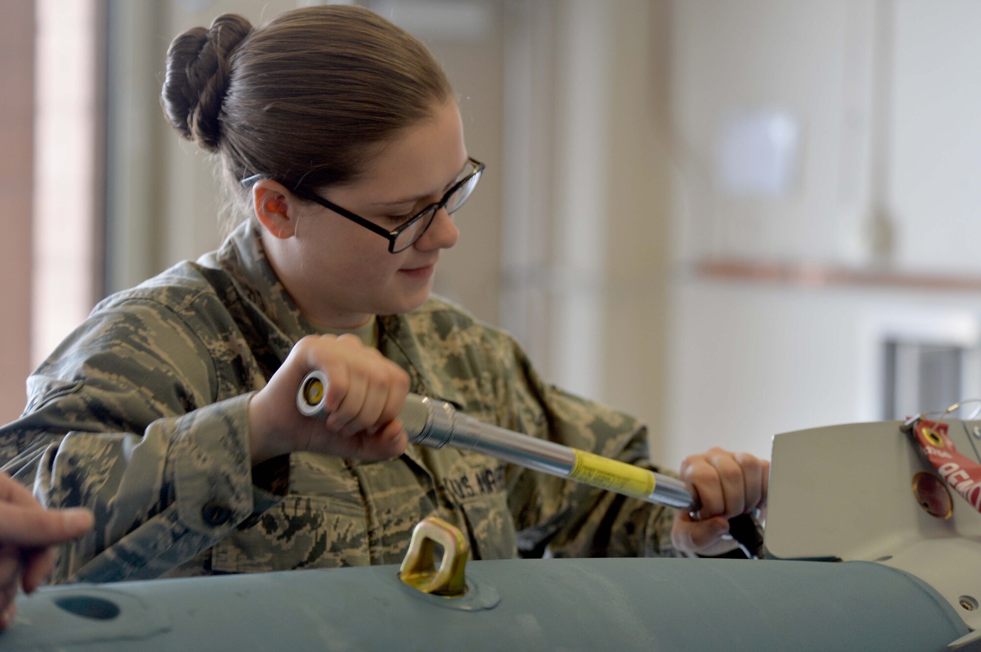 Airman Emily, 432nd Maintenance Squadron munitions flight crew member, performs maintenance on an inert GBU-12 Paveway ll laser-guided bomb April 27, 2016, at Creech Air Force Base, Nevada. Emily has recently finished her career development courses and will soon deploy in support of MQ-1 and MQ-9 missions downrange. (U.S. Air Force photo by Airman 1st Class Kristan Campbell/Released).