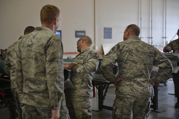 Col. Case Cunningham, 432nd Wing/432nd Air Expeditionary Wing commander, left, and Chief Michael Ditore, 432nd Wg/432nd AEW command chief, right, look on as Staff Sgt. Adam, 432nd Maintenance Squadron munitions flight crew chief, performs maintenance on an inert GBU-12 Paveway ll laser-guided bomb on April 27, 2016, at Creech Air Force Base, Nevada. Cunningham and Ditore assisted the Airmen with building six inert GBU-12 laser-guided bombs to be used for MQ -9 Reaper aircraft training. (U.S. Air Force photo by Airman 1st Class Kristan Campbell/Released).

