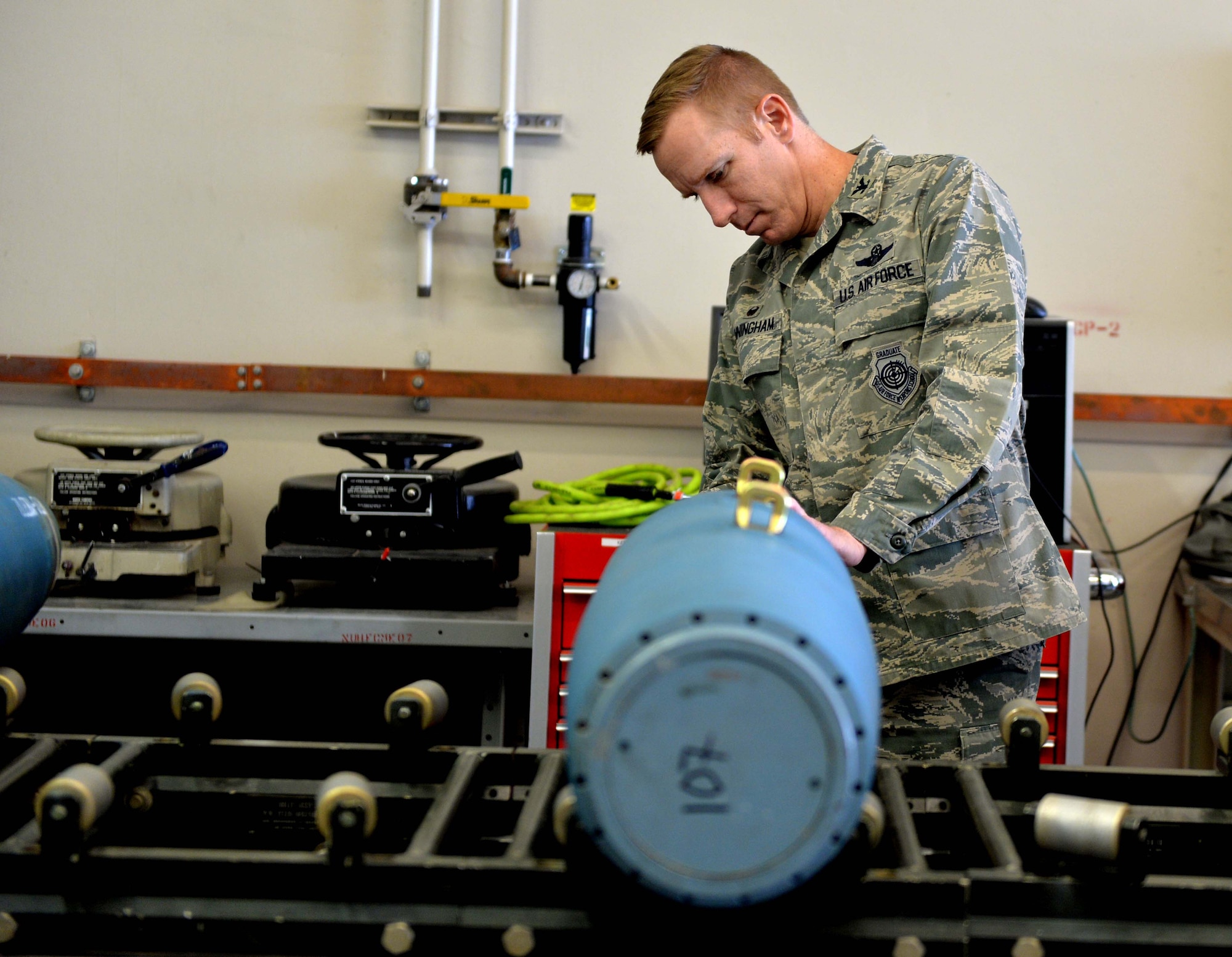Col. Case Cunningham, 432nd Wing/432nd Air Expeditionary Wing commander, performs maintenance on an inert GBU-12 Paveway II laser-guided bomb April 27, 2016, at Creech Air Force Base, Nevada.  The bombs built will be used for MQ -9 Reaper aircraft training. Cunningham and Chief Master Sgt. Ditore, 432nd Wg/432nd AEW command chief, spent approximately two hours with the munition flight’s production section to perform the build. (U.S. Air Force photo by Airman 1st Class Kristan Campbell/Released).
