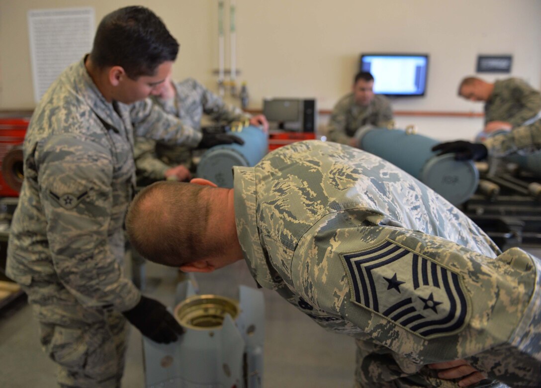 Chief Master Sgt. Michael Ditore, 432nd Wing/432nd Air Expeditionary Wing command chief, and Airman Andrew, 432nd Maintenance Squadron munitions flight crew member, inspect the inside of an inert GBU-12 Paveway II laser-guided bomb April 27, 2016 at Creech Air Force Base, Nevada. Although building and transporting explosives is a big part of operations, the munitions flight crew also serves as a weapons and tactics liaison for the base, and is responsible for over 70,000 pounds of explosive weight used to support MQ-1 and MQ-9 missions. (U.S. Air Force photo by Airman 1st Class Kristan Campbell/Released).
