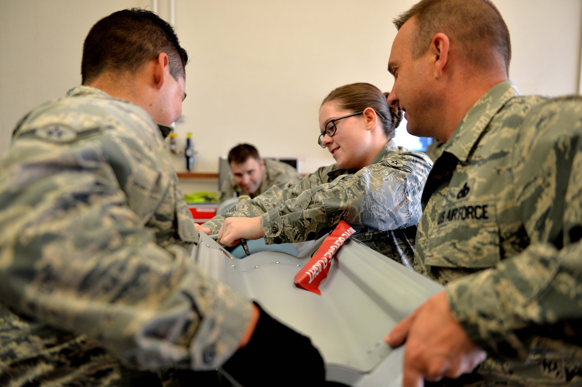 Chief Master Sgt. Michael Ditore, 432nd Wing/432nd Air Expeditionary Wing command chief assists Airman Andrew and Airman Emily, both 432nd Maintenance Squadron munitions flight crew members to perform maintenance on six inert GBU-12 Paveway II laser-guided bombs April 27, 2016, at Creech Air Force Base, Nevada. Col. Case Cunningham, 432nd Wg/432nd AEW commander, also assisted in the build as part of Ditore’s shadow an Airman initiative, a program implemented as an avenue for Ditore and Cunningham to meet their Airmen and boost morale within the wing. (U.S. Air Force photo by Airman 1st Class Kristan Campbell/Released).