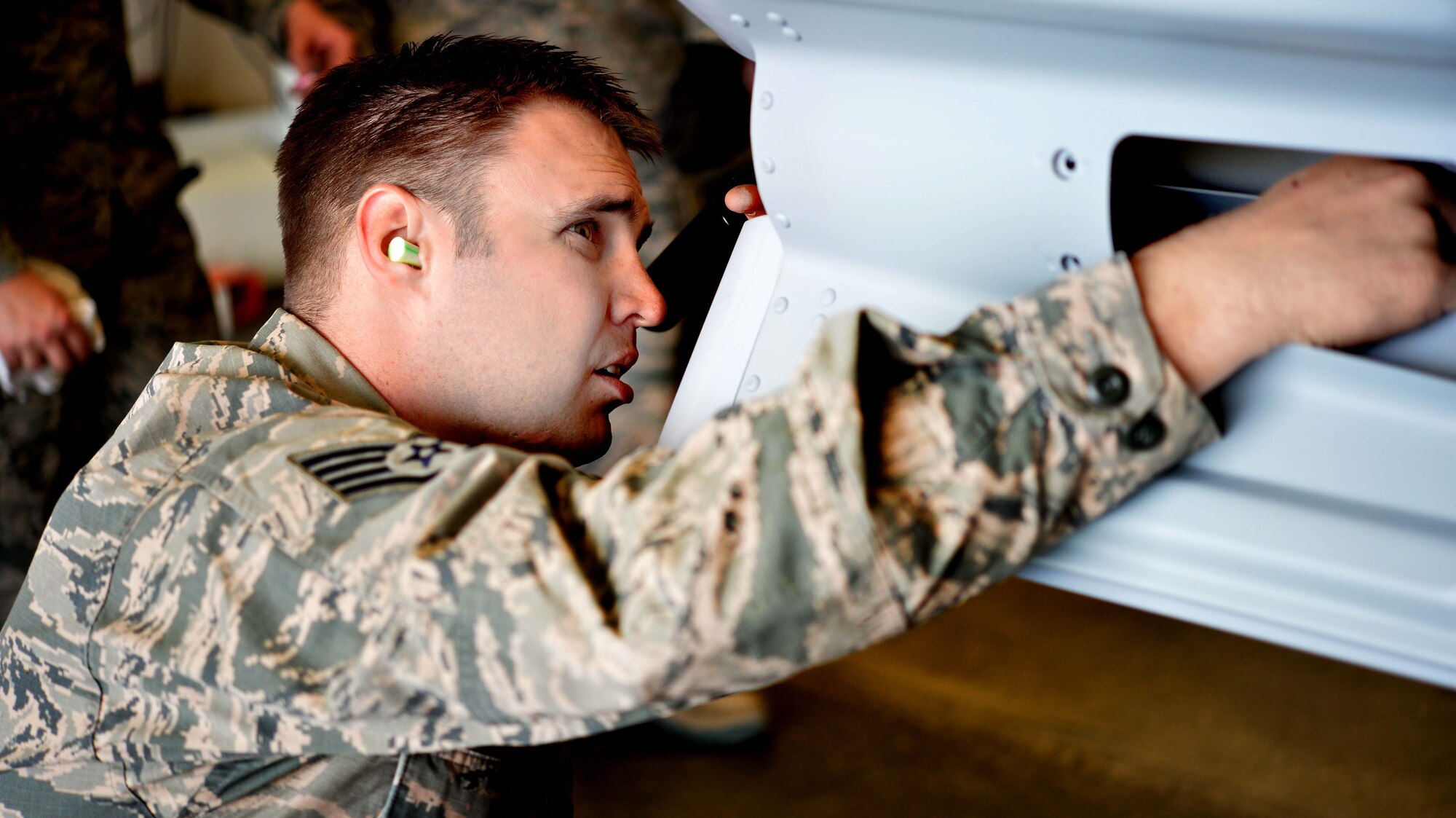Staff Sgt. Anthony, 432nd Maintenance Squadron munitions flight crew chief, inspects an inert GBU-12 Paveway ll laser-guided bomb April 27, 2016, at Creech Air Force Base, Nevada. Anthony, NCO in-charge of the six GBU-12 munitions build, explained technical orders to Col. Case Cunningham, 432nd Wing/432nd Air Expeditionary Wing commander, and Chief Master Sgt. Michael Ditore, 432nd Wg/432nd AEW command chief. Cunningham and Ditore assisted the Airmen with building the bombs and learned how ammo Airmen supply weapons to the MQ-1 and MQ-9 aircraft on base. (U.S. Air Force photo by Airman 1st Class Kristan Campbell/Released).