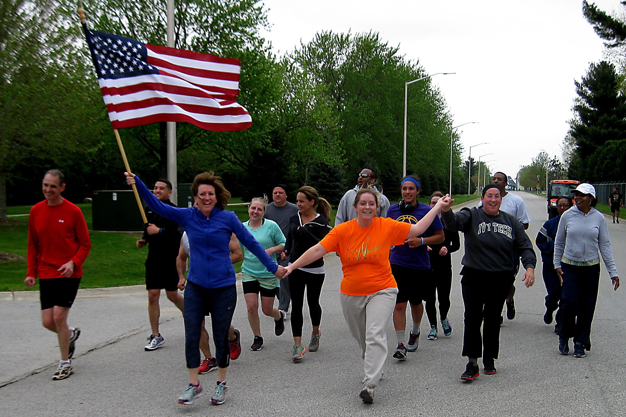 Participants in the 2016 Plastic Egg Run encourage the final team as they approach the finish line April 27, 2016 at Grissom Air Reserve Base, Ind. At various intervals during the 5K run teams had to stop and select a plastic egg which contained a challenge to complete before moving on to the next station, the final challenge was to hold hands and skip to the finish line. (U.S. Air Force photo/Senior Airman Dakota Bergl)
