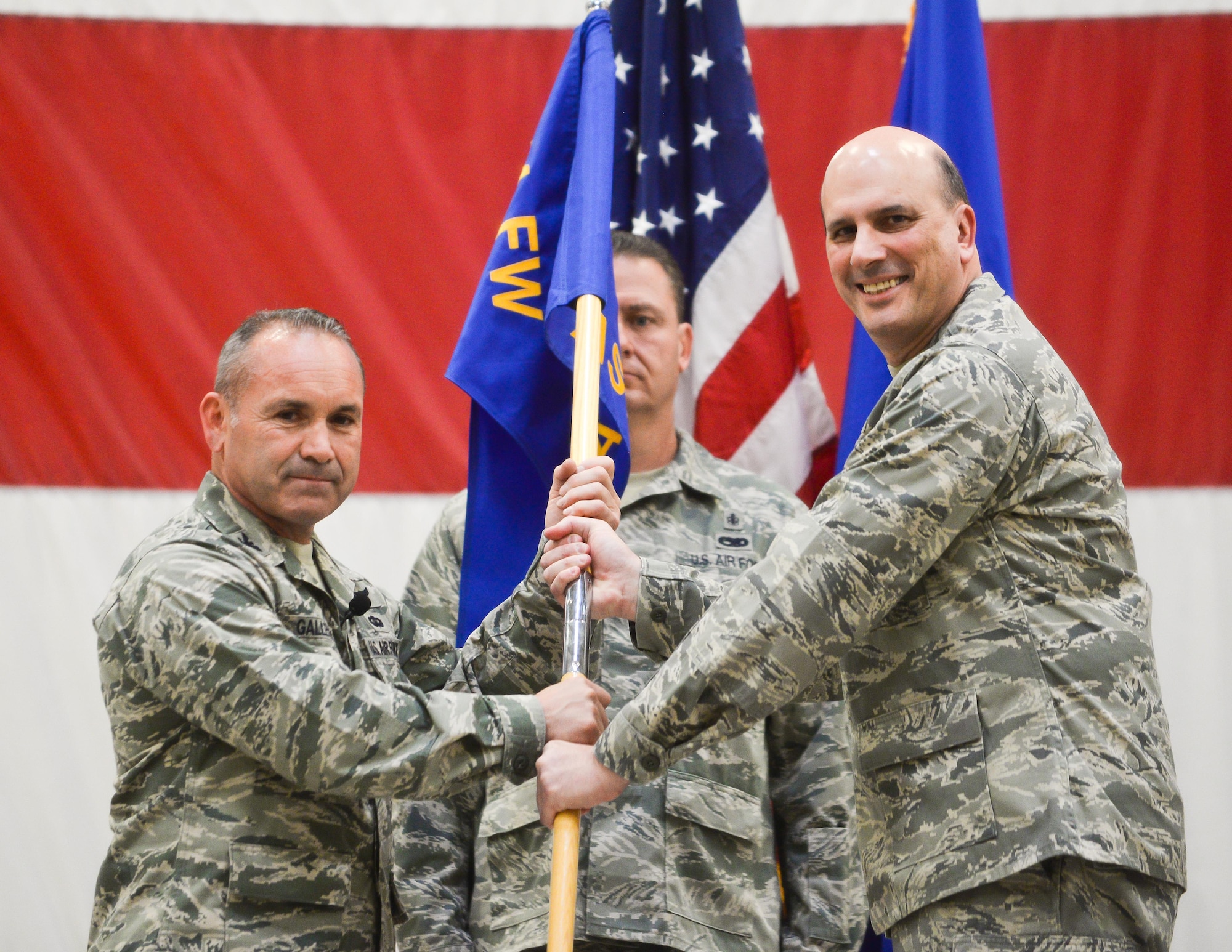 Col. Kurt Gallegos, 944th Fighter Wing commander, hands the aeromedical staging squadron guidon to Col. Alfred Rossum, 944 Aeromedical Squadron commander, during a change-of-command ceremony April 30 at Luke Air Force Base, Ariz. (U.S. Air Force photo by Staff Sgt. Nestor Cruz)