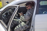 Staff Sgt. Matthew Cummings, 902nd Security Forces Squadron patrolman, checks identification cards Aug. 8 at Joint Base San Antonio-Randolph's East Gate.