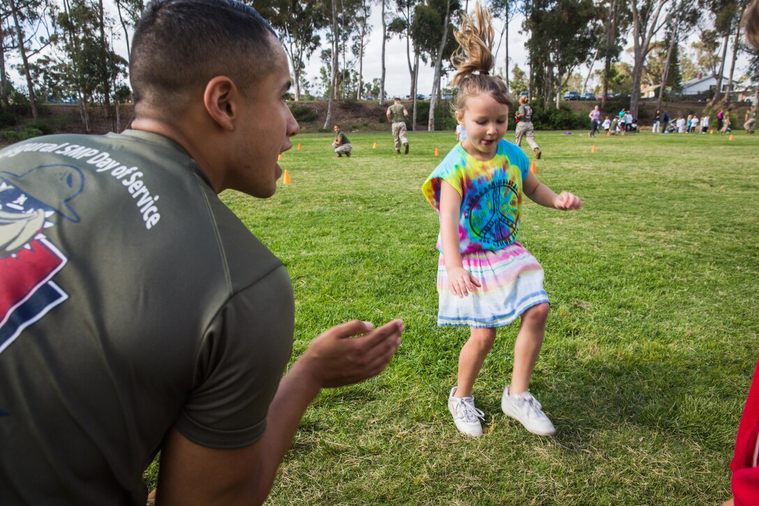 Pfc. Brodie Cantrell, a volunteer with the Single Marine Program aboard Marine Corps Air Station Miramar, and a Slaton, Texas, native, gives directions to a student at Miramar Ranch Elementary School in San Diego, April 29. The Marines volunteered for a P.E. Fitness Challenge, an event which allowed children and Marines to complete a series of exercises throughout the course of the school day. (U.S. Marine Corps photo by Sgt. Lillian Stephens/Released)