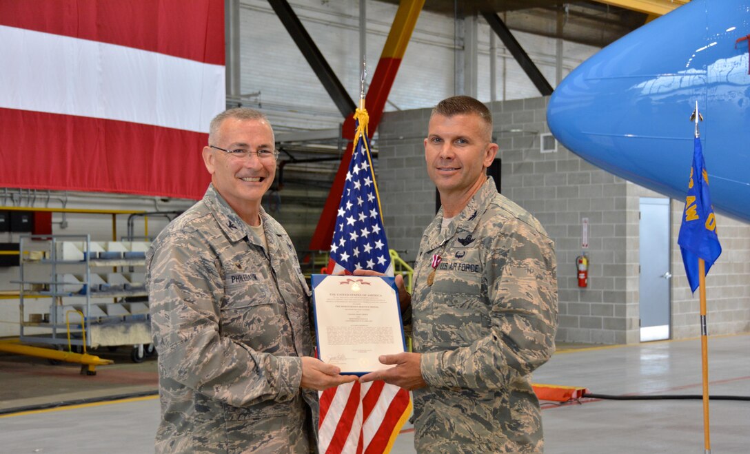 At right, Col. Sean Pierce, the outgoing 932nd Operation Group commander, is presented a Meritorious Service Medal by the wing commander, Col. Jonathan Philebaum, for his work at the 932nd Airlift Wing overseeing the distinguished visitor airlift plane.  The C-40C plane is used to transport DV worldwide as part of the 932nd Airlift Wing, under 22nd Air Force, Air Force Reserve Command.  (U.S. Air Force photo by Staff Sgt. Jodi Ames)