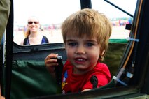 A child pretends to be a pilot in a biplane during the 2016 Defenders of Liberty Airshow at Barksdale Air Force Base, La., April 30. The Defenders of Liberty Airshow provides many exhibits for kids in addition to the aircraft performances. (U.S. Air Force photo/Airman 1st Class Luke Hill)