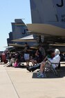 Spectators enjoy performances while staying cool underneath a F-15E Strike Eagle static display during the 2016 Defenders of Liberty Airshow at Barksdale Air Force Base, La., April 30. Held for the first time in 1933, the Barksdale Air Force Base air show is a full weekend of military and civilian aircraft and performances and displays. (U.S. Air Force photo/Airman Alexis C. Frost)