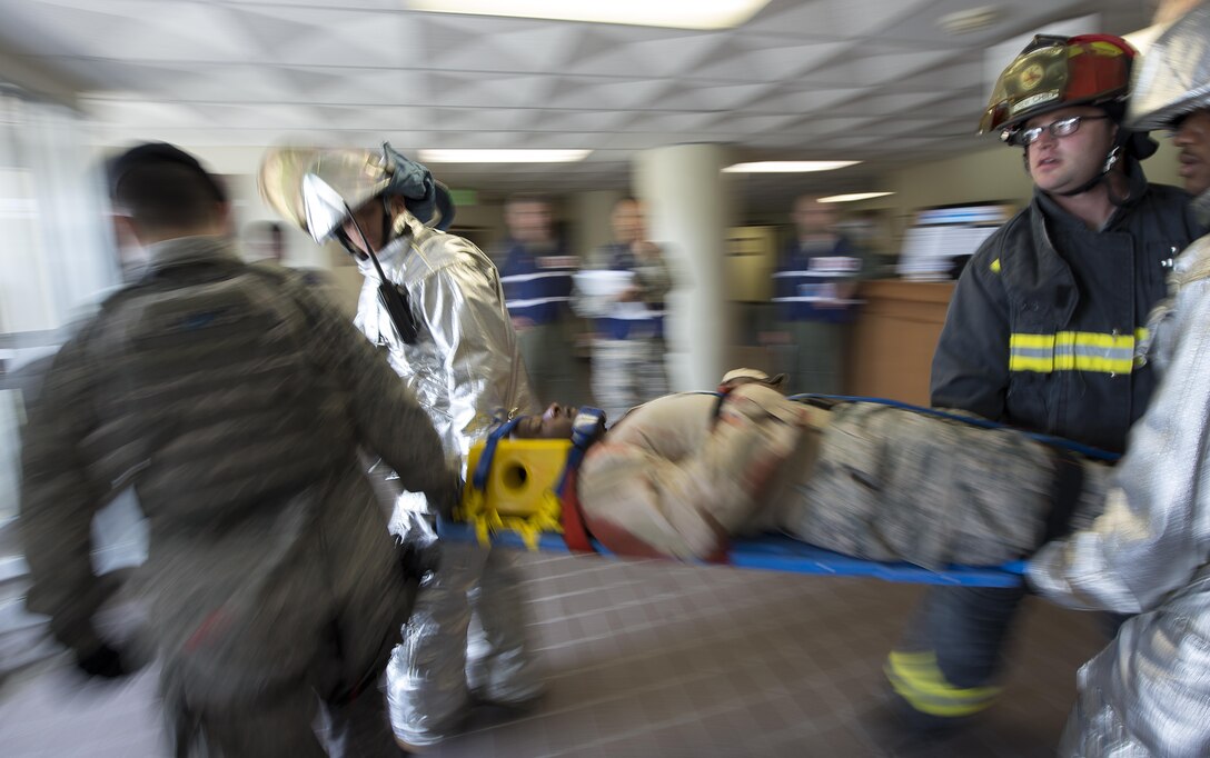 U.S. Air Force emergency responders carry a simulated casualty using a litter, at Kadena Air Base, Japan, during an active shooter exercise May 4, 2016. During the scenario, a lone simulated gunman invaded the 18th Wing Legal Office and fought against 18th Security Forces Squadron emergency responders. The exercise provided a sense of realism and better prepared the responders for future real-world contingencies.  (U.S. Air Force photo by Staff Sgt. Maeson L. Elleman/Released)