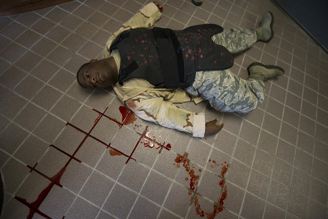 A U.S. Air Force member with the 18th Security Forces Squadron and the perpetrator of a simulated active shooter exercise lies on the ground after a brief simulated fire fight with emergency responders, at Kadena Air Base, Japan, during an active shooter scenario May 4, 2016. For this exercise, security forces responders and the active shooter were authorized to use simulated ammunition for the first time in order to better prepare the responders for potential real-world scenarios. (U.S. Air Force photo by Staff Sgt. Maeson L. Elleman/Released)
