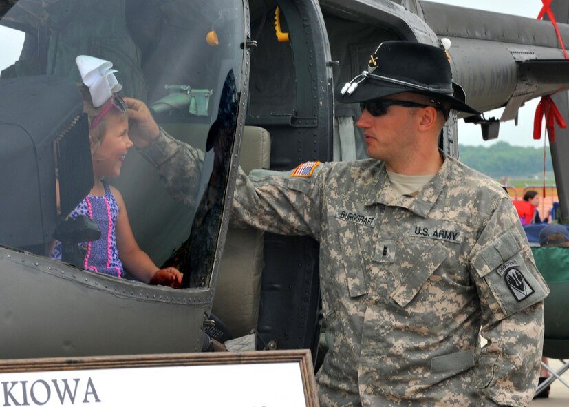 U.S. Army Chief Warrant Officer 3 Cory Burggraff adjusts a child’s sunglasses as she sits in the cockpit of an OH-58D Kiowa armed reconnaissance helicopter during the 2016 Defenders of Liberty Airshow at Barksdale Air Force Base, La., May 1. Thousands of visitors toured static displays during the air show, getting up close with more than 60 aircraft on the ramp. (U.S. Air Force photo/Senior Airman Joseph Raatz)