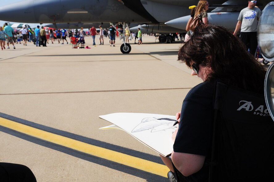 Sharon LaBorde, a local production artist, sketches the F-15 Strike Eagle during the 2016 Defenders of Liberty Airshow on Barksdale Air Force Base, La., May 1. LaBorde says the air show gives her the opportunity to sketch these aircraft up close and personal. (U.S. Air Force photo/Airman Alexis C. Frost)
