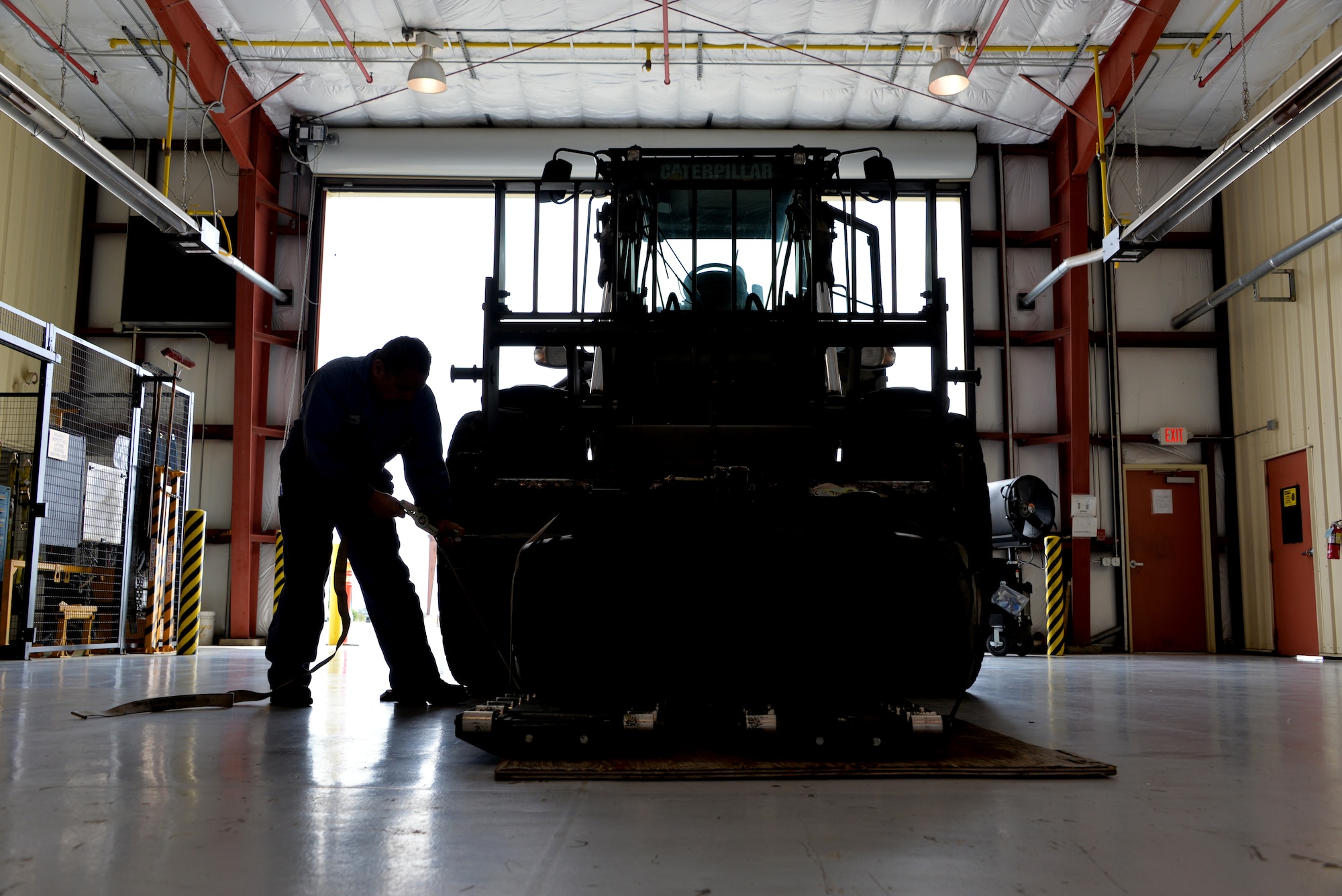 Cesar Ponce, 60th Logistics Readiness Squadron heavy vehicle mechanic, checks the tie down straps for a kit loaded on a 10K Forklift April 26, 2016, at Travis Air Force Base, California. The kit contains spare parts and supplies needed when the forklift is sent on deployment. (U.S. Air Force photo by Staff Sgt. Charles Rivezzo)
