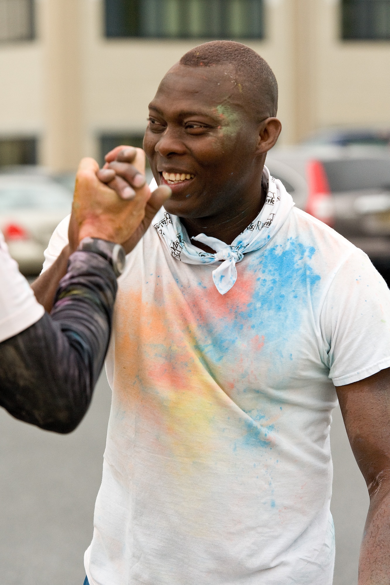 Staff Sgt. Olorunyomi Martins, 436th Airlift Wing Judge Advocate office receives a congratulatory handshake at the finish line April 28, 2016, on Dover Air Force Base, Del. Eighty-one Team Dover members participated in the 5K Color Run. (U.S. Air Force photo/Roland Balik)