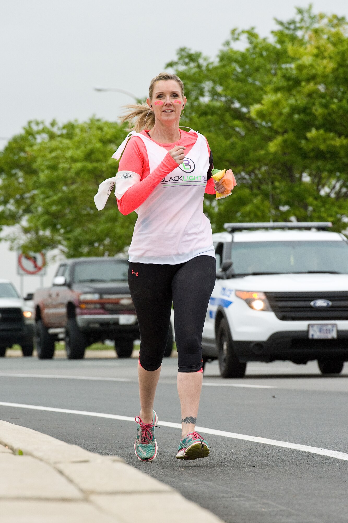 Master Sgt. Jillian Swanson, Air Force Mortuary Affairs Operations honor guard program manager, runs toward the main gate during the 5K Color Run, April 28, 2016, on Dover Air Force Base, Del. Eight-one runners started near the main gate and ran across the Route 1 bridge toward the housing area entry control point before turning back to the base. (U.S. Air Force photo/Roland Balik)
