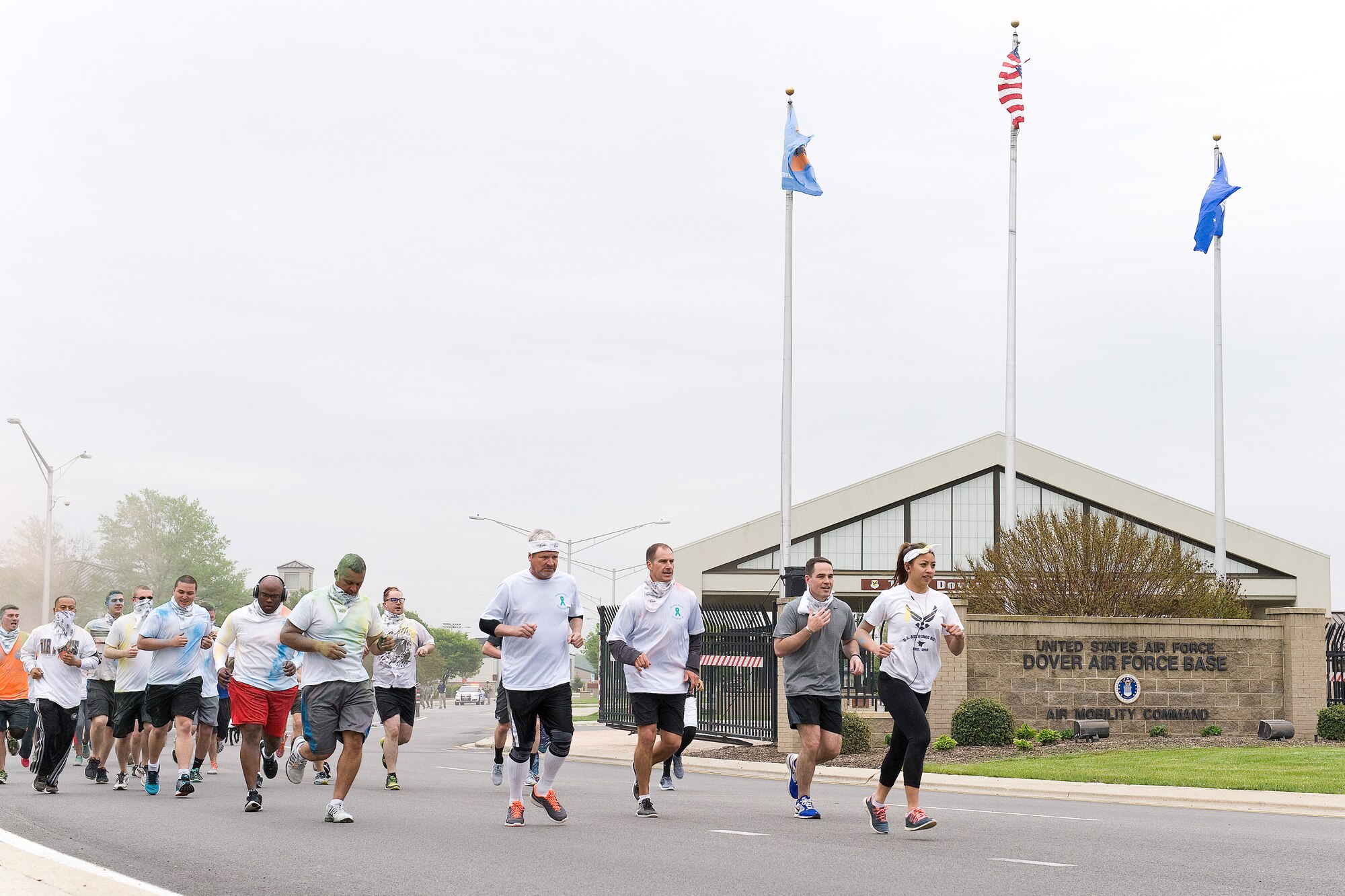 Second Lt. Dawn Marie Ressurreccion, 436th Force Support Squadron, leads Team Dover runners out of the main gate near the 5K Color Run starting line April 28, 2016, on Dover Air Force Base, Del. Eighty-one Team Dover members participated in the Color Run on a course that took runners off and back onto the base. (U.S. Air Force photo/Roland Balik)