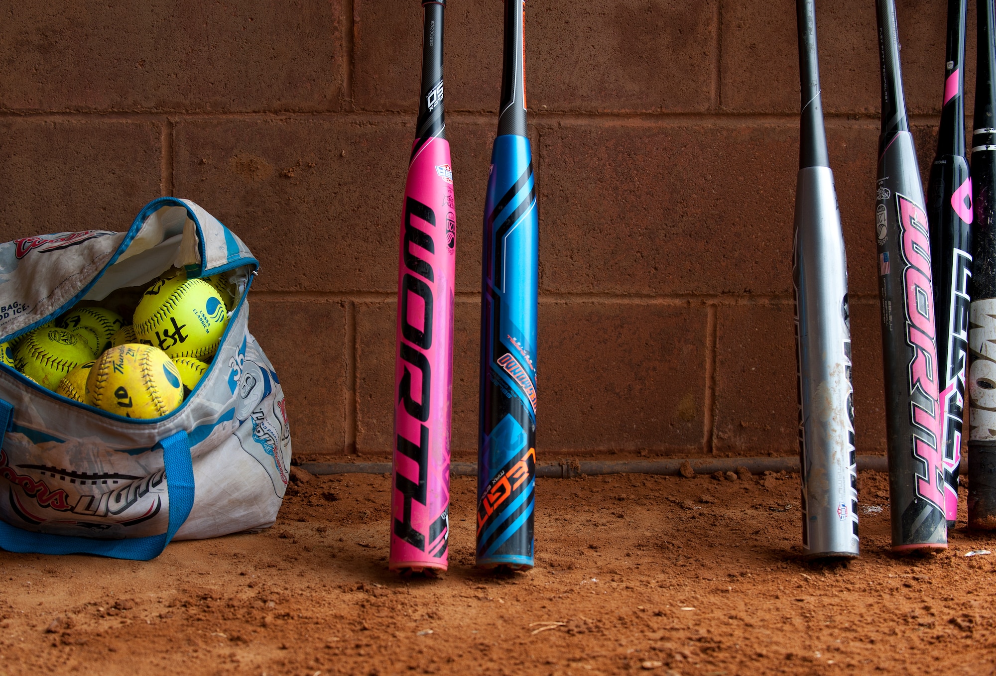 A collection of bats and balls sits in a dugout for the 2nd Annual Kings of the Bay Softball Tournament at Langley Air Force Base, Va., April 30, 2016. About 150 players and spectators gathered to witness seven teams battle to earn the first place trophy. (U.S. Air Force photo by Airman 1st Class Kaylee Dubois).