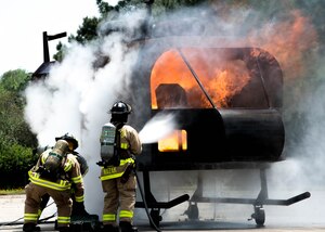 Fort Eustis fire department fire fighters extinguish a fire and rescue a training aide during an aircraft live fire exercise at Fort Eustis, Va., April 27, 2016. The Fort Eustis fire department conducts semiannual aircraft live fire training to meet U.S. Air Force training requirements. (U.S. Air Force photo by Staff Sgt. J.D. Strong II)