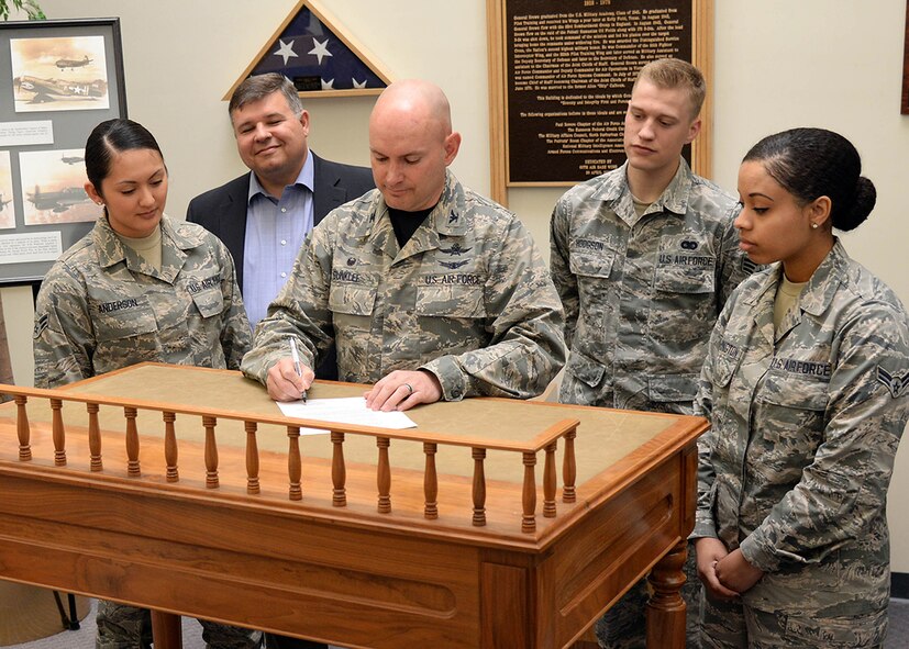 Col. David R. Dunklee, center, 66th Air Base Group commander, signs a proclamation April 29 declaring May 1-8 as the Days of Remembrance of the Victims of the Holocaust as Airman 1st Class Michele Anderson, from left-to-right, Thomas Fredericks, Senior Airman Randy Hodgson and Airman 1st Class Lavona Washington looks on. The United States Congress established the Days of Remembrance as the nation's annual commemoration of the Holocaust, which includes the Holocaust Remembrance Day, Yom Hashoah, on May 5. The theme of this year's observance is Learning from the Holocaust: Acts of Courage. (U.S. Air Force photo by Linda LaBonte Britt)