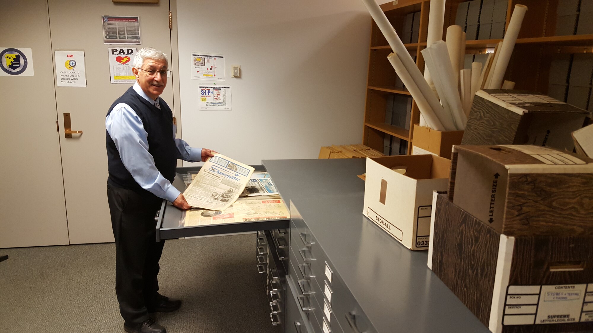 Dr. Henry Narducci, historian for the Air Force Life Cycle Management Center displays a 1986 edition of the Wright-Patterson AFB newspaper. (U.S. Air Force photo / Brian Brackens)