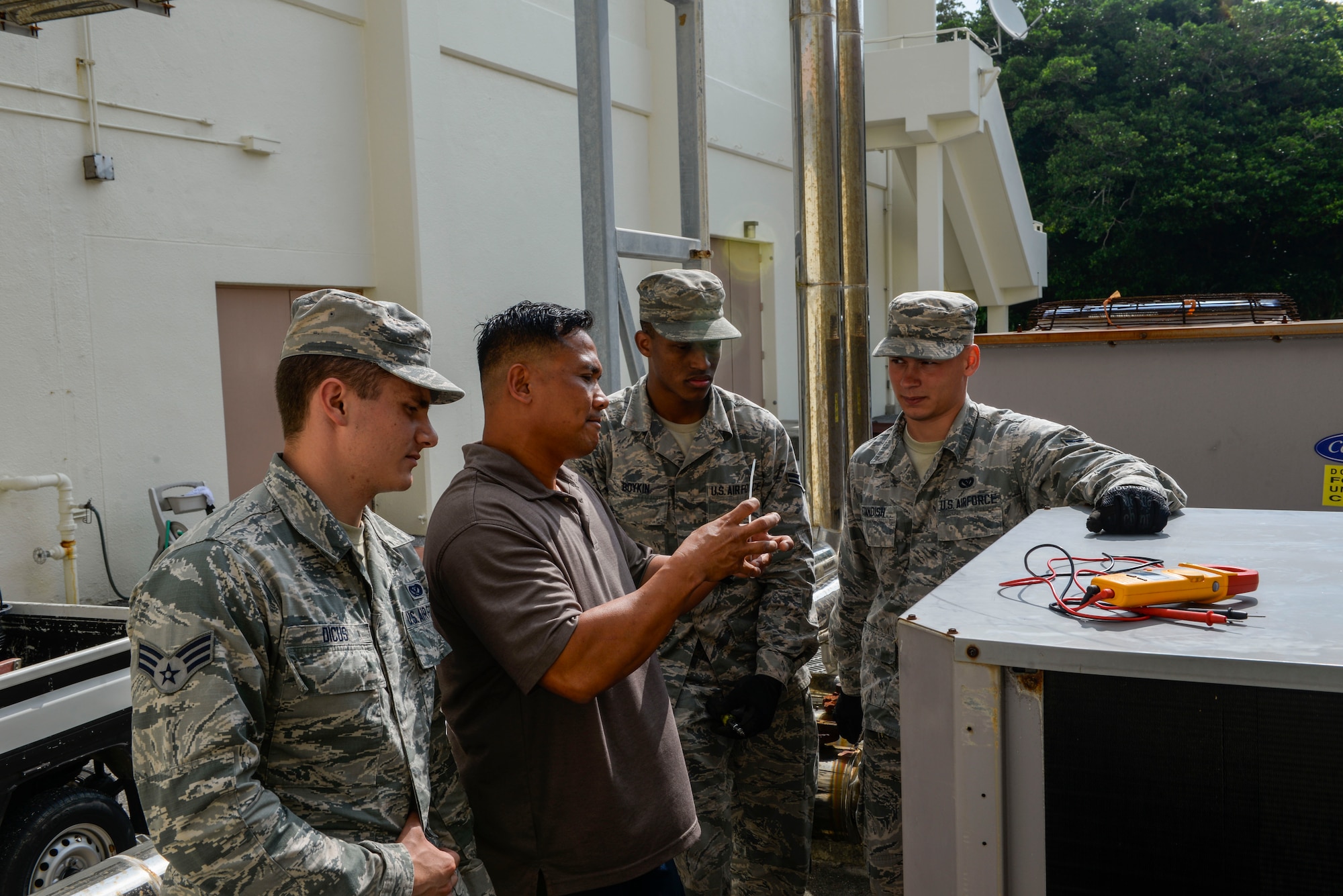 Mr. Aladin Nono, 18th Civil Engineer Squadron heating, ventilation and air conditioning equipment maintainer, explains to Airmen how to check for mechanical and electrical failures in a condensor fan system April 28, 2016, at Kadena Air Base, Japan. HVAC supports more than 2,000 operational and maintenance facilities across Kadena, Okuma, White Beach and Yaedake while maintaining more than 28,000 pieces of mechanical equipment. (U.S. Air Force photo by Senior Airman Stephen G. Eigel)