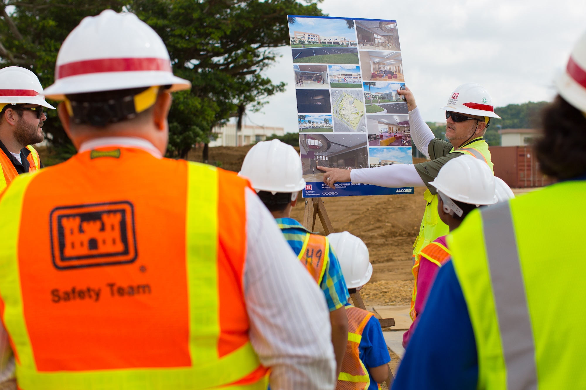 Tim Runquist, quality assurance representative, Japan Engineer District, U.S. Army Corps of Engineers, presents model pictures of what the finished Kadena Elementary School building will look like April 7, 2016, at Kadena Air Base, Japan. The new $70 million school will be the first 21st century school built on Okinawa, and the largest free-standing building on Kadena. (Courtesy photo)