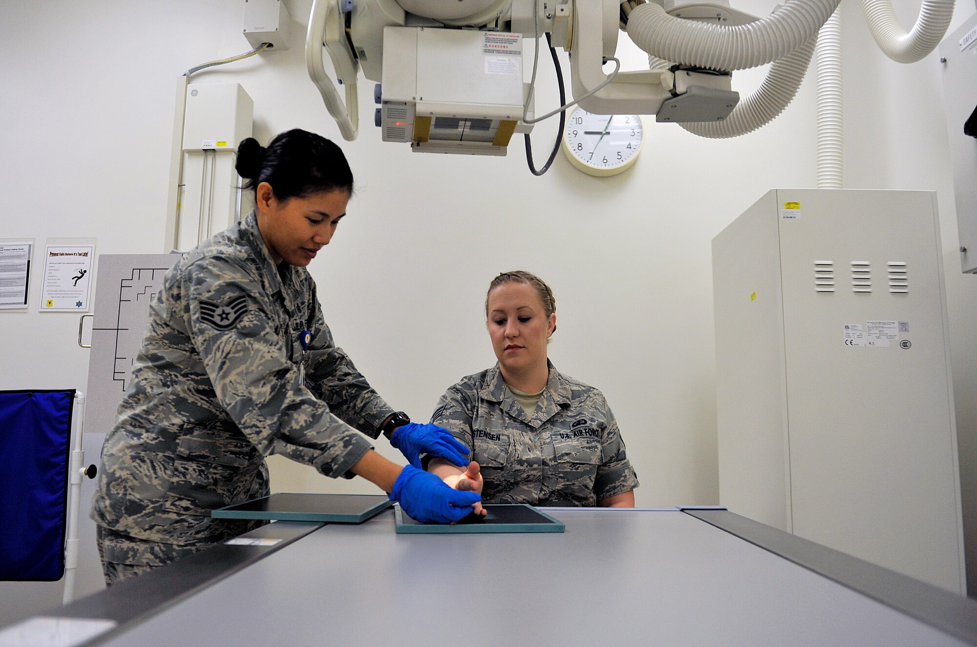 U.S. Air Force Staff Sgt. Mariecrist Shuty, 18th Medical Support Squadron radiology technologist, positions the wrist of Senior Airman Miranda Christensen, 18th Contracting Squadron contracting specialist, April 29, 2016, at Kadena Air Base, Japan. The 18th MDSS radiology section averages more than 300 patients per month. (U.S. Air Force photo by Naoto Anazawa)
