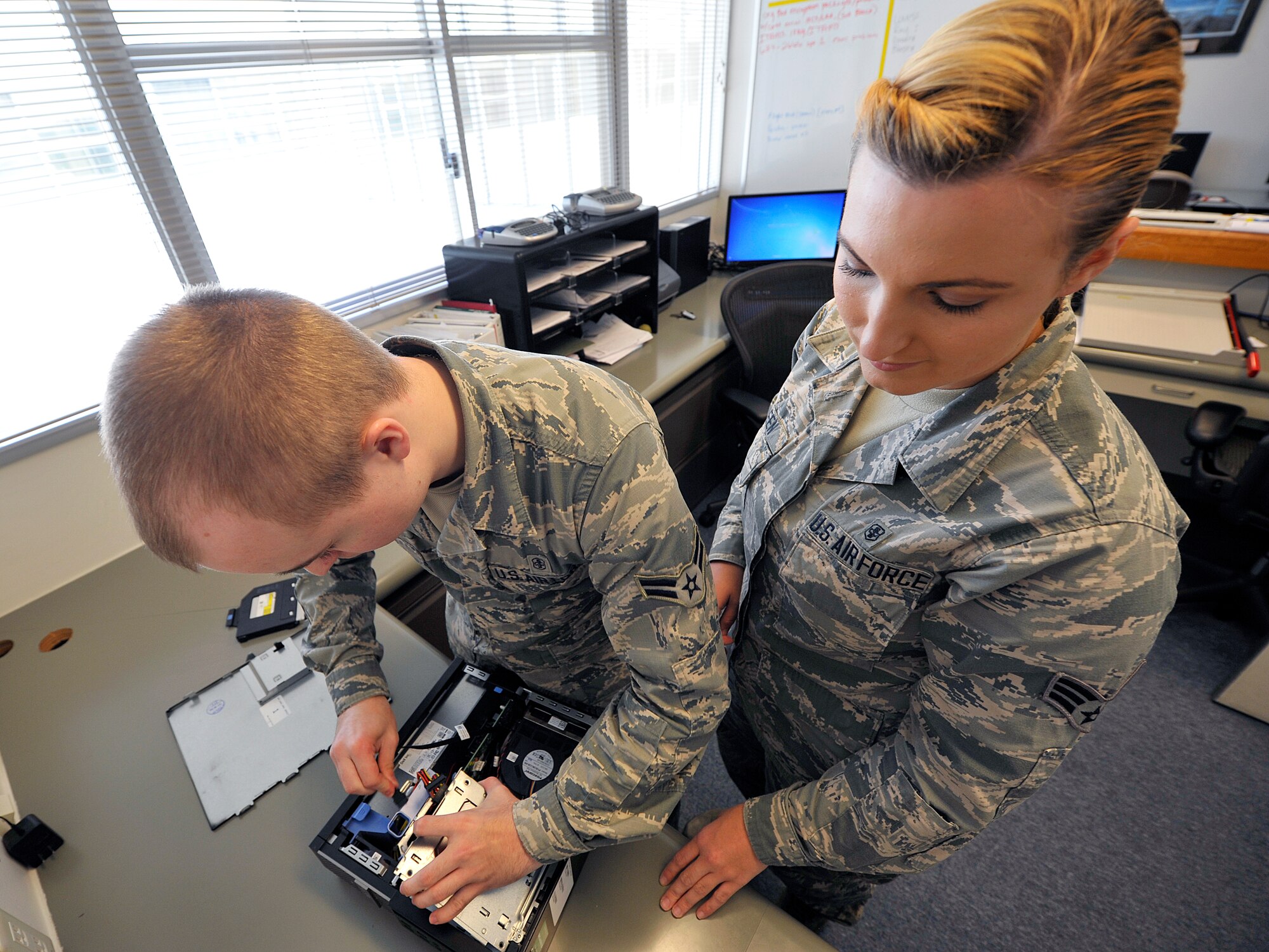 U.S. Air Force Airman 1st Class Peter Risch, 18th Medical Support Squadron medical information service technician and Senior Airman Brittney Green, 18th MDSS medical information service technician, install a work station hard drive, May 4, 2016, at Kadena Air Base, Japan. The 18th Medical Support Squadron enhances and controls all financial, manpower, facility, supply and equipment issues in support of a $35.5 million budget and Pacific Air Forces' largest war readiness material program valued at $9.3 million. (U.S. Air Force photo by Naoto Anazawa)
