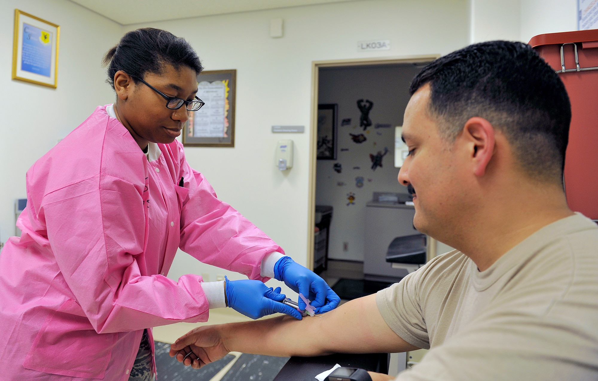 U.S. Air Force Staff Sgt. Ashley Johnson, 18th Medical Support Squadron microbiology section supervisor, takes a blood sample from Master Sgt. Michael Garcia, 18th Medical Support Squadron flight chief, May 2, 2016, at Kadena Air Base, Japan. The 18th MDSS laboratory section averages more than 70 patients per day. There are a variety of samples collected at the laboratory to determine whether an individual is healthy or not, such as blood, urine or sweat sample tests. (U.S. Air Force photo by Naoto Anazawa)

