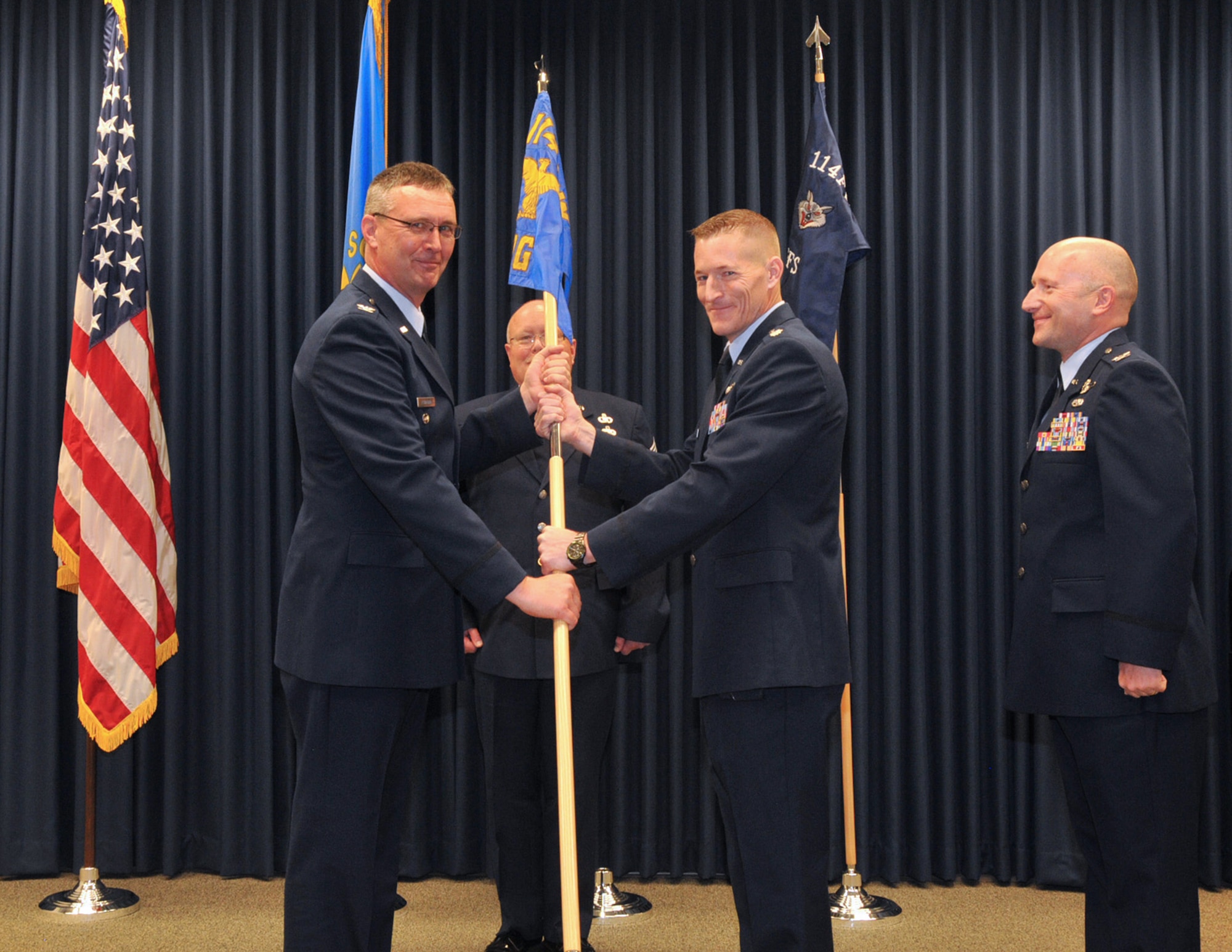 Col. Nate Alholinna, 114th Fighter Wing commander, passes the 114th Operations Group guidon flag to Lt. Col. Quenten Esser as he assumes command of the 114th Operations Group effective May 1, 2016. (U.S. Air National Guard photo by Master Sgt. Christopher Stewart/Released)