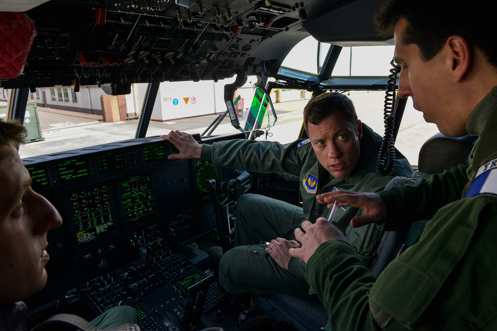 U.S. and French Airmen discuss the features of a C-130J Super Hercules aircraft cockpit April 28, 2016, at Ramstein Air Base, Germany. French military personnel met with aircrew from the 37th Airlift Squadron to survey a C-130J and become familiar with its operations. (U.S. Air Force Photo/ Airman 1st Class Lane Plummer)