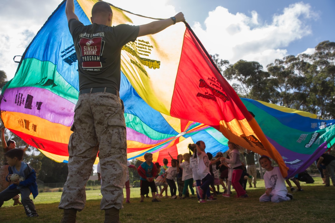 Lance Cpl. Chase McManaman, a volunteer with the Single Marine Program at Marine Corps Air Station Miramar holds a parachute during a group activity at Miramar Ranch Elementary School in San Diego, April 29. The Marines volunteered for a P.E. Fitness Challenge, which allowed children and Marines to complete a series of exercise stations during the course of the school day. 