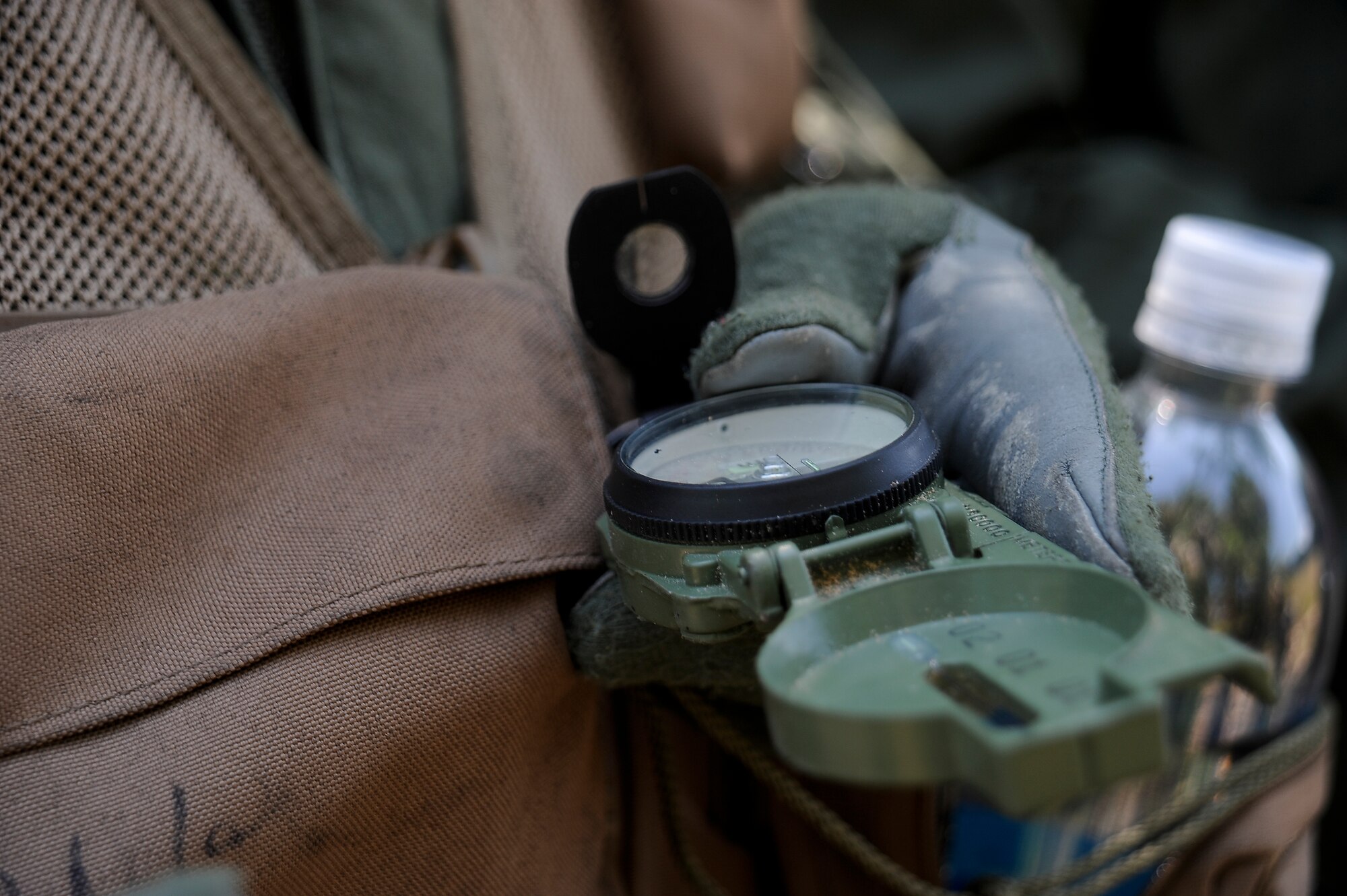An Airman uses his compass to find the correct direction during Survival, Evasion, Resistance, and Escape combat survival training at MacDill Air Force Base, Fla., April 27, 2016. After instructional training, Airmen tested out their skills during a simulated exercise. (U.S. Air Force photo by Airman 1st Class Mariette Adams)