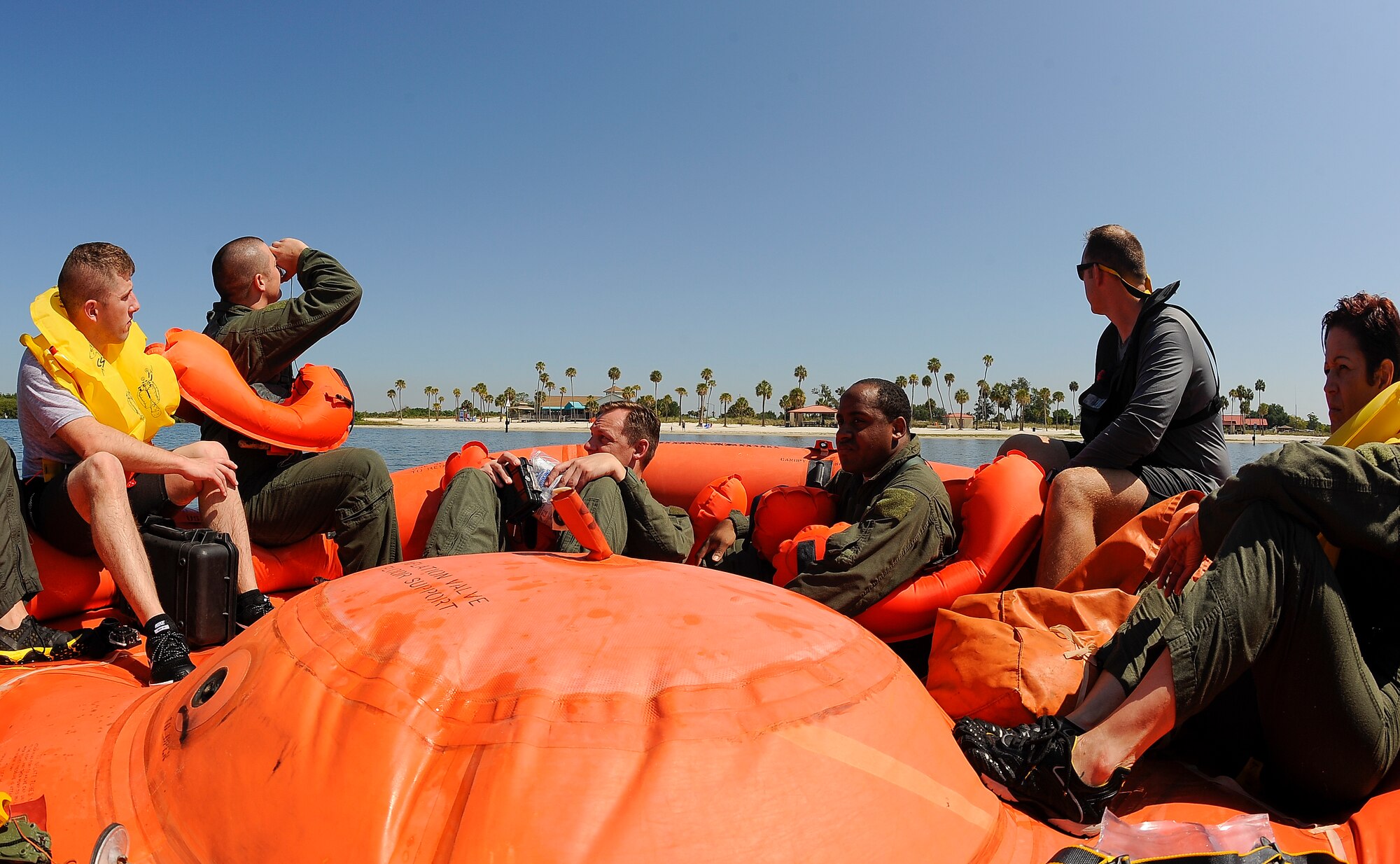 Aircrew members from the various squadrons practice using a mirror to attract attention for rescue during water survival training at MacDill Air Force Base, Fla., April 29, 2016. After instructional training, Airmen tested their skills during a simulated exercise. (U.S. Air Force photo by Airman 1st Class Mariette Adams)