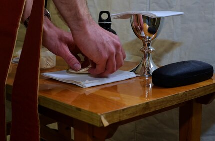 The Reverend Giles Allen (CF), of the Royal Army Chaplain’s Department (RAChD), prepares the Eucharist worship service held during exercise Anakonda Response 2016 at Papa Air Base, Hungary, May 1, 2016. The exercise was organized by the 7th Mission Support Command, an Army Reserve unit based in Kaiserslautern, Germany. (U.S. Air National Guard photo by Tech. Sgt. Andria Allmond)