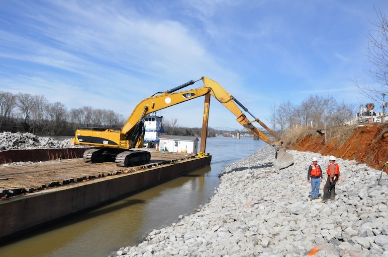 Crews from the Choctaw Transportation, Inc. from Dyersburg, Tenn., cleared and prepared the bank along the Cumberland River in Clarksville, Tenn., and used barges equipped with backhoe tractors to place a layers of geotextile fabric and riprap with limestone rock to stabilize the eroding bank. The project is part of the Riverside Drive Stream Bank Stabilization Project.   