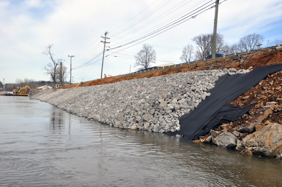 The U. S.  Army Corps of Engineers Nashville District and the city of Clarksville celebrated the completion of the Riverside Drive StreamBank Stabilization Project today during a ceremony at Freedom Point in Liberty Park. Crews cleared and prepared the site and used barges equipped with backhoe tractors to place a layers of geotextile fabric and riprap with limestone rock to stabilize the eroding bank.