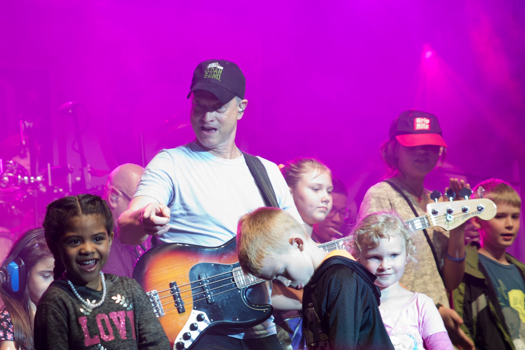Surrounded by children, actor and musician, Gary Sinise, performs with the Lt. Dan Band at Little Rock Air Force Base, Ark., April 29, 2016. The band, which is associated with the actor's charity foundation and the United Service Organizations, perform more than 40 concerts for military members and their families each year. (Courtesy photo by Eva Walston)
