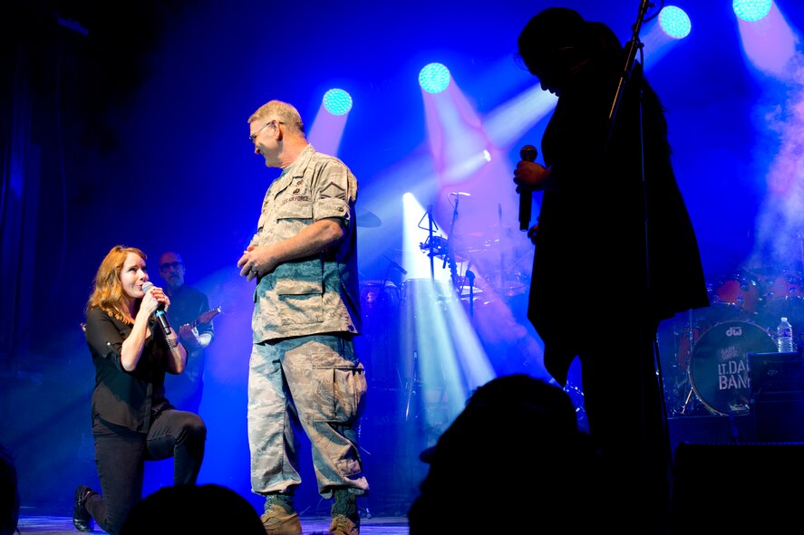 (Left) Vocalists, Julie Dutchak and Mari Anne Jayme, vie for the attention of U.S. Air Force Reserve Master Sgt. Jeff Walston, 913th Airlift Group, as they serenade him during a free concert by Gary Sinise and the Lt. Dan Band at Little Rock Air Force Base, Ark., April 29, 2016. The band, which is associated with the Sinise's charity foundation and the United Service Organizations, perform more than 40 concerts for military members and their families each year. (Courtesy photo by Eva Walston)
