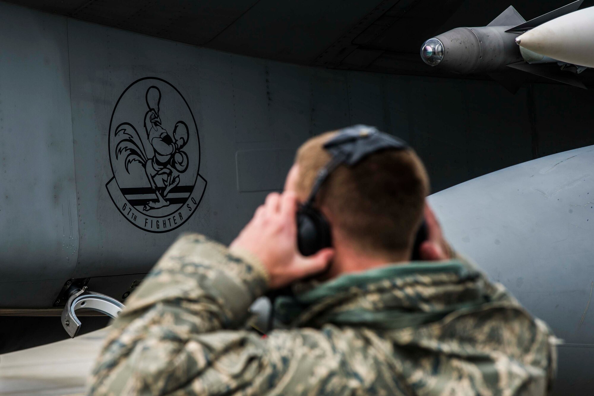 U.S. Air Force Senior Airman Dyllan Jones, a crew chief assigned to the 67th Aircraft Maintenance Unit, Kadena Air Base, Japan, adjusts his headset at Eielson Air Force Base, Alaska, May 3, 2016, during RED FLAG-Alaska (RF-A) 16-1. Jones uses a headset connected to the aircraft to communicate with the pilot while preparing the jet for the launch. (U.S. Air Force photo by Staff Sgt. Joshua Turner/Released)