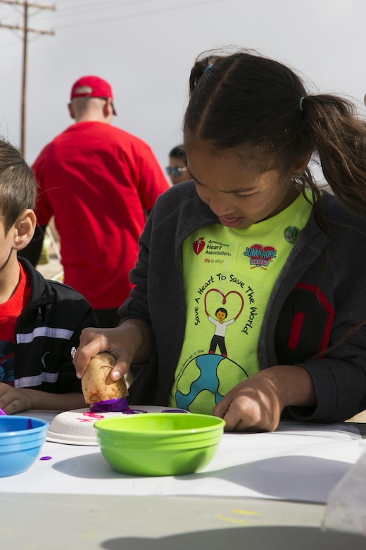Gabriella Posey, 7, daughter of Rachael Posey, spouse, paints paper plates using stamps made from potatoes during the Healthy Kids Day hosted by the Armed Services YMCA at Felix Field aboard the Combat Center April 30, 2016. The children were able to express creativity as they learned about healthy foods.  (Official Marine Corps photo by Lance Cpl. Dave Flores/Released)