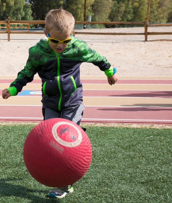 Landon Gerasimovich, 5, son of Petty Officer 3rd Class Mike Gerasimovich, Physical Therapist, Robert E. Bush Naval Hospital, plays kickball with the other children at the Healthy Kids Day hosted by the Armed Services YMCA at Felix Field aboard the Combat Center April 30, 2016. (Official Marine Corps photo by Lance Cpl. Dave Flores/Released)