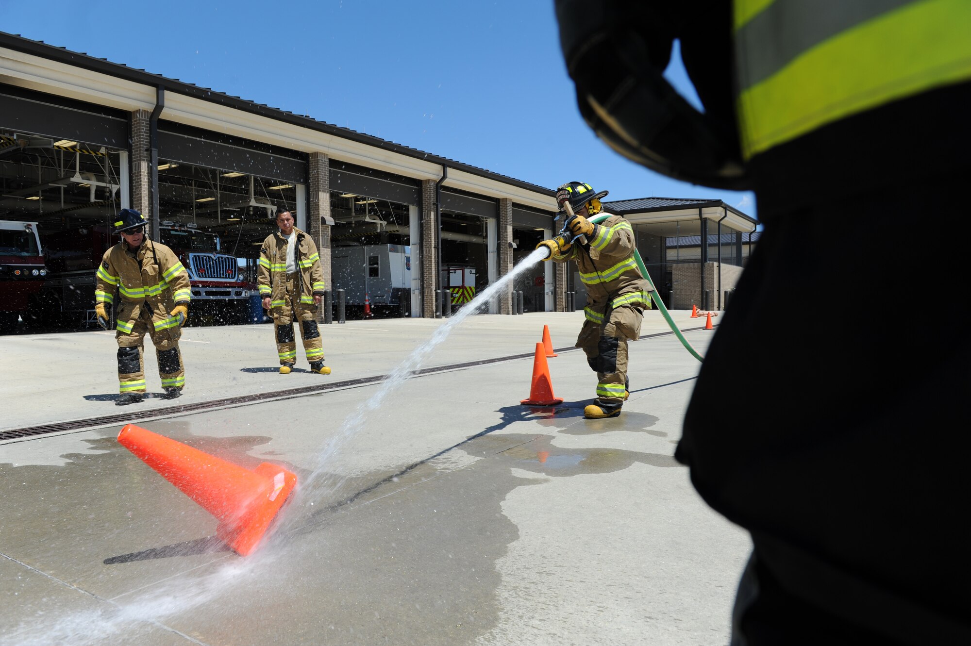 Senior Airman Jonathan Martinez, 81st Infrastructure Division firefighter, knocks down a cone with a fire hose at the Keesler Fire Department as he trains for the 2016 Firefighter Combat Challenge Competition Wild Card Week, May 4, 2016, Keesler Air Force Base, Miss. Four members from the fire department competed in the qualifying round at Lake Charles, La., Apr. 30. (U.S. Air Force photo by Kemberly Groue)