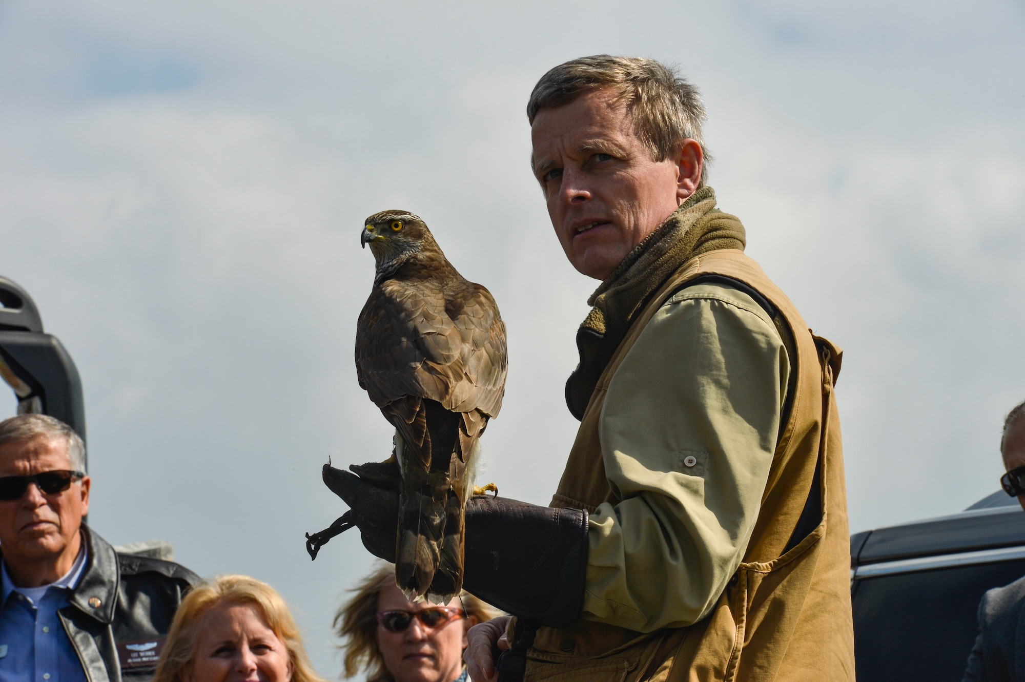 Jens Fleer, a falconer, shows his gyrfalcon used for flightline bird abatement on Spangdahlem Air Base, Germany, to a group of Air Force civic leaders April 19, 2016, during a weeklong civic leader trip to several bases in Europe. Air Force civic leaders are unpaid advisers, key communicators and advocates for the Air Force. (U.S. Air Force photo/Tech. Sgt. Joshua DeMotts)